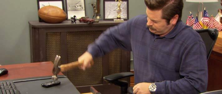 Ron Swanson smashing cell phone with a hammer